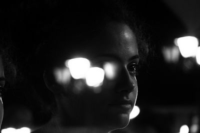 Close-up portrait of young man against illuminated light