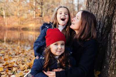Portrait of happy daughters with mother in park