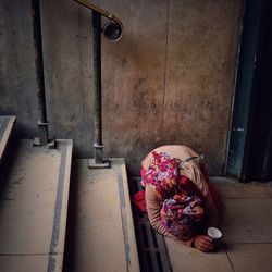 Female beggar begging by staircase