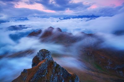 Scenic view of mountains against cloudy sky
