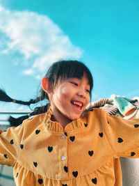 Portrait of young woman standing against sky