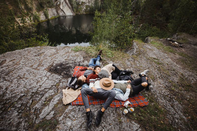 High angle view of people sitting on rock