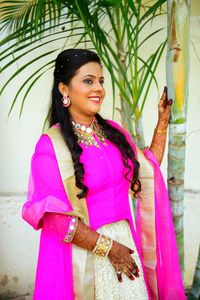 Portrait of smiling young woman standing against pink petals