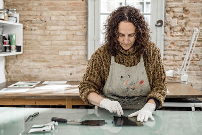 Woman artist preparing ink for an art print. using an ink stick