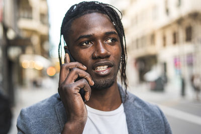 Portrait of young man holding city street