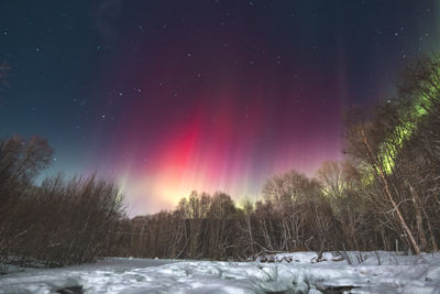 Snow covered landscape against sky at night