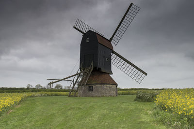 Traditional windmill on field against sky