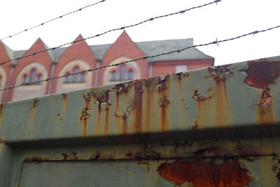 Low angle view of rusty metal against sky