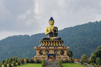 Low angle view of statue against trees