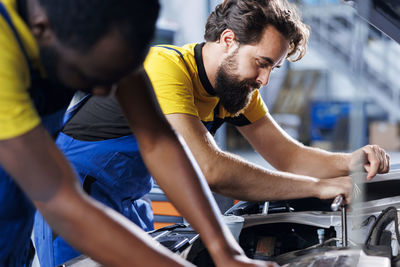 Side view of young man working at workshop