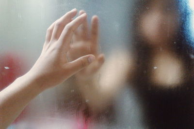 Reflection of woman touching frosted glass