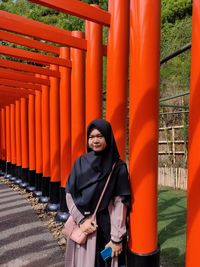 Full length of woman standing against orange wall