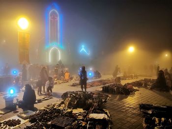 People on illuminated city at night