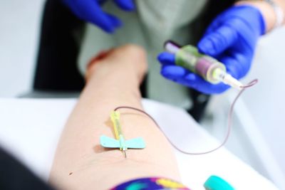 Cropped image of doctor giving iv drip to patient in hospital