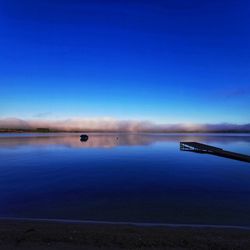 Scenic view of lake against clear blue sky