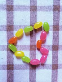 Directly above shot of candies arranged as heart shape on table