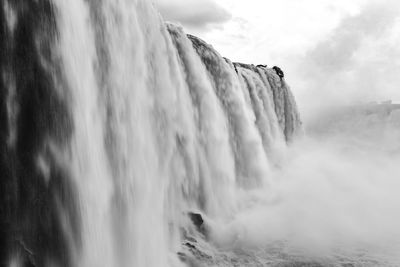 Scenic view of waterfall against sky