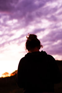 Rear view of silhouette man standing against sky at sunset