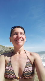 Woman at beach against blue sky