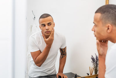 Young couple looking away against wall