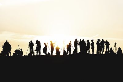 Silhouette people against clear sky during sunset