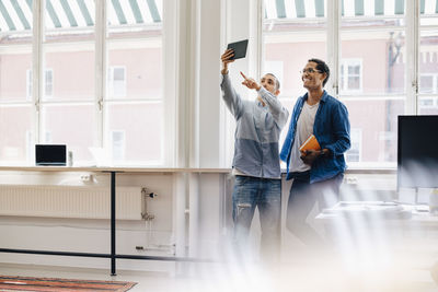 Male computer hackers taking selfie while standing in office