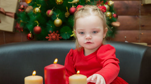 A girl looks at the burning candles christmas evening with interest and curiosity. person