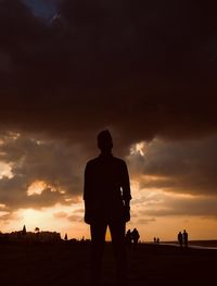 Silhouette man standing against sky during sunset