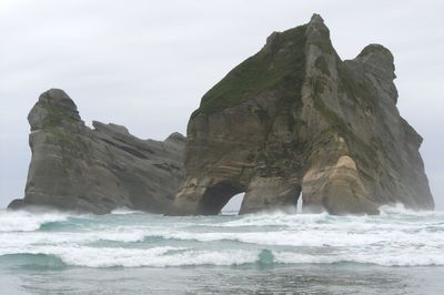 Scenic view of sea by cliff against sky