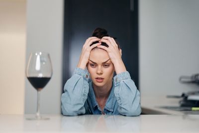 Portrait of young woman holding wineglass at home