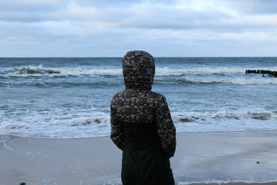 Rear view of woman standing on beach