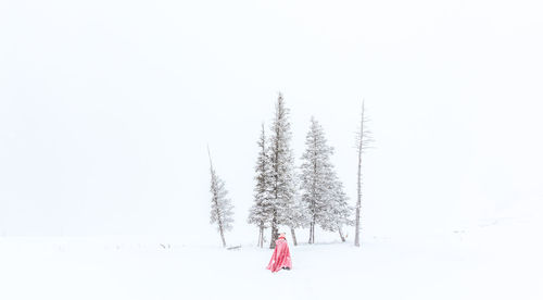 A woman walking on snow covered field