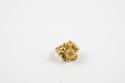 Close-up of gold ring over white background