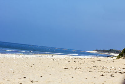 Scenic view of beach against clear blue sky