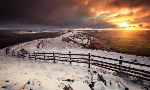 Scenic view of snow covered mountain against dramatic sky