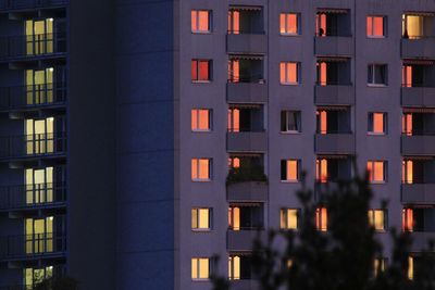 Full frame of skyscraper on sunset with red windows reflecting the sunlight