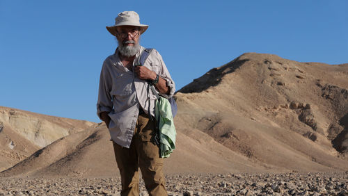 Senior man standing on mountain in the desert 