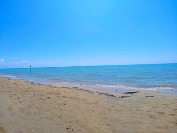 Scenic view of beach against blue sky