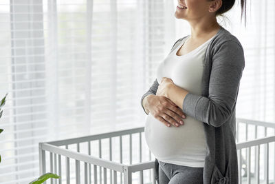 Midsection of woman standing against wall