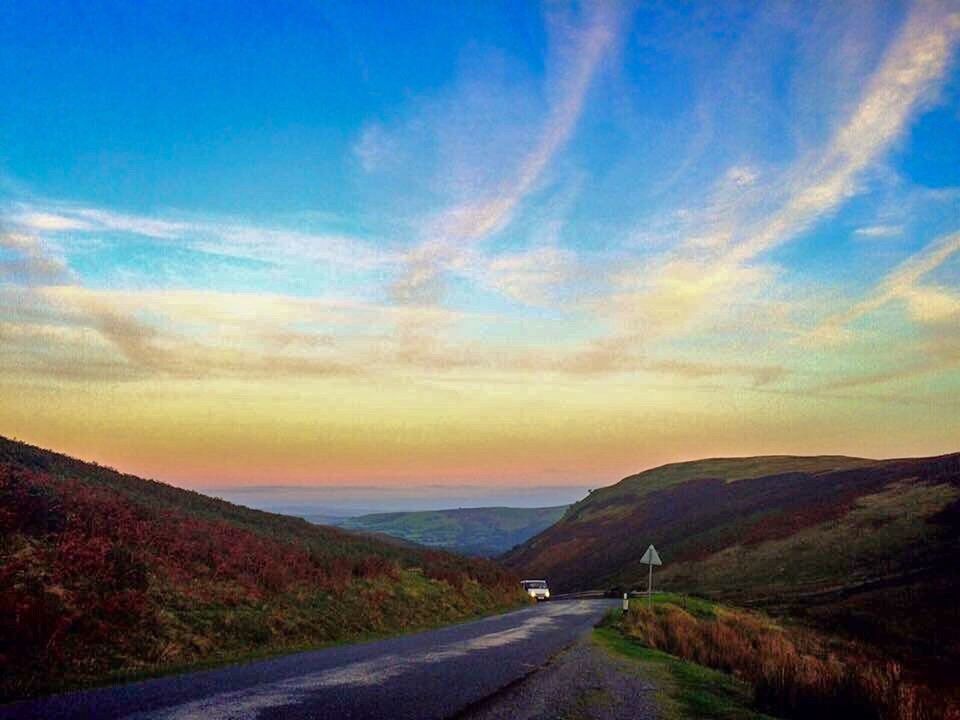 road, transportation, the way forward, tranquil scene, landscape, mountain, country road, diminishing perspective, road marking, vanishing point, empty, sky, countryside, non-urban scene, remote, cloud, tranquility, solitude, mountain range, long, scenics, idyllic, blue, dramatic sky, nature, outdoors, yellow line, narrow, day, beauty in nature, white line, cloud - sky, mountain road, majestic