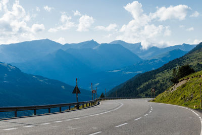 Road by mountains against sky