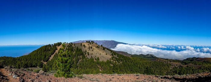 Scenic view of mountains against blue sky