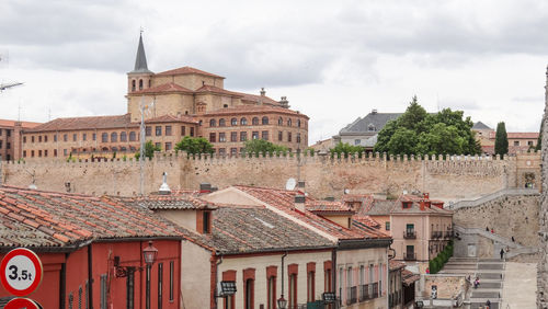 Buildings in town against cloudy sky