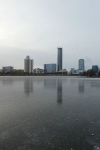 River by buildings against sky in city