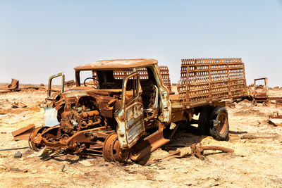 Old abandoned truck on field against sky