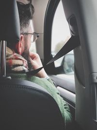 Portrait of man seen through car window