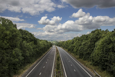 Road amidst trees against sky