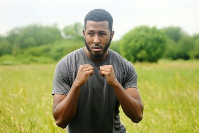 Young man in fighting stance standing on field