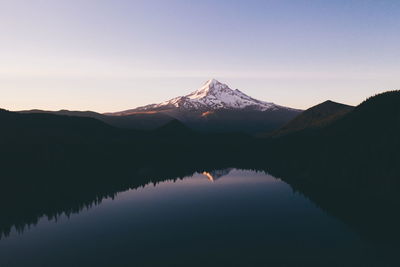 Scenic view of lake and mountains against sky during sunset