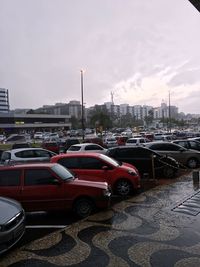 Cars on road in city against sky